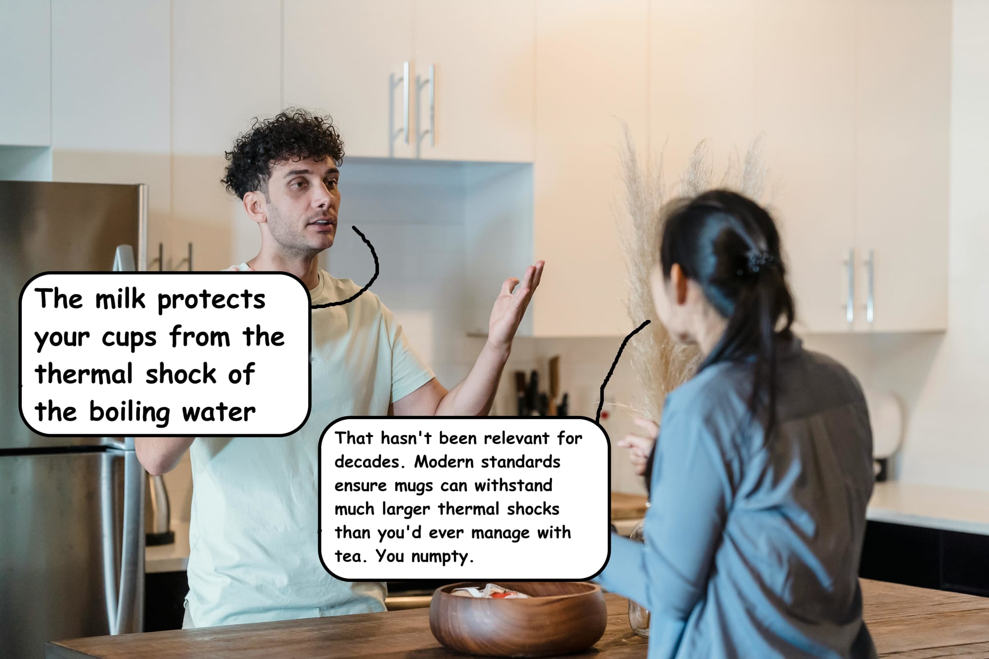 Man shouting at woman: The milk protects your cups from the thermal shock of the boiling water. Woman Retorts: That hasn't been relevant for decades. Modern standards ensure mugs can withstand much larger thermal shocks than you'd ever manage with tea. You numpty